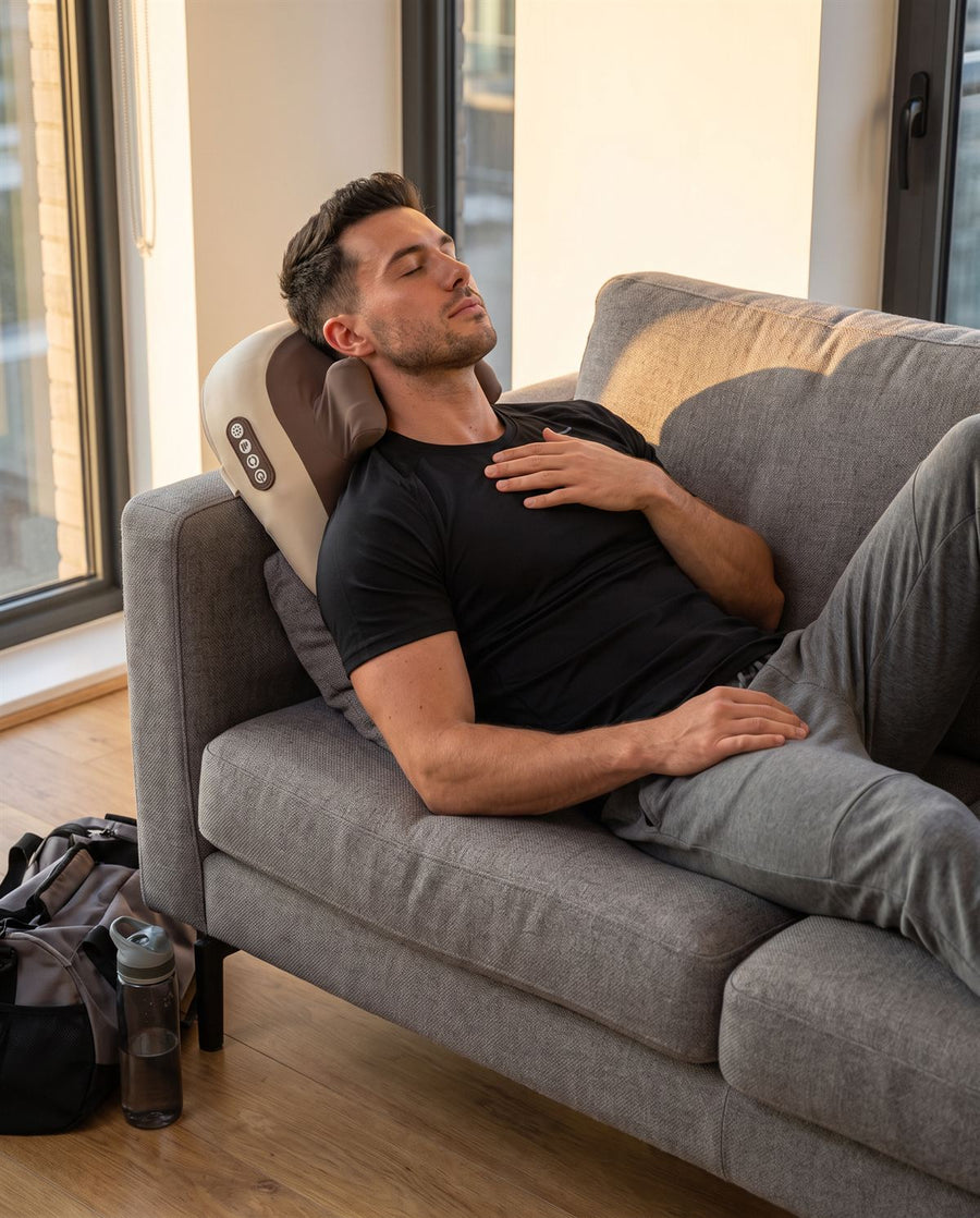 Man lying back on Hizoo on the sofa after the gym