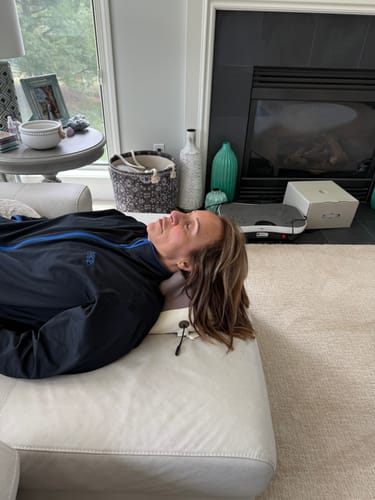 Madeline B. lying on an ottoman with Hizoo under her neck